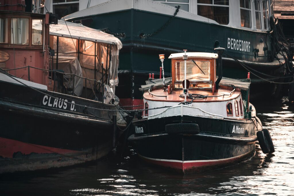 Charming vintage tugboats moored at Hamburg harbor under soft evening light.